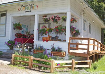 the grange porch full of hanging flower pots